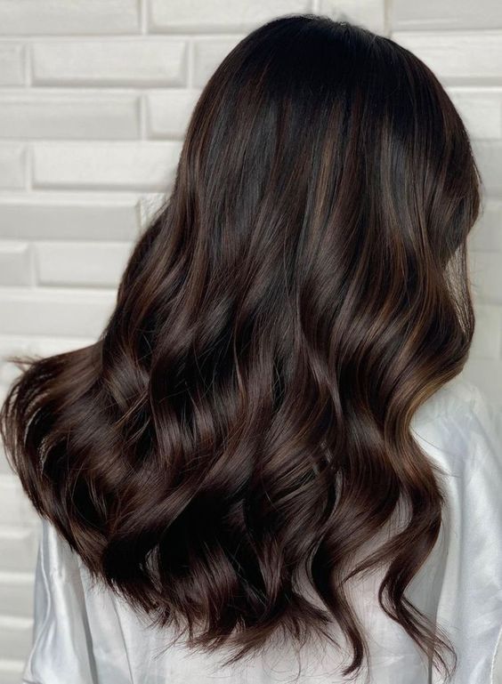 fantastic dark brown hair with waves and volume and delicate chestnut balayage is a beautiful solution for now