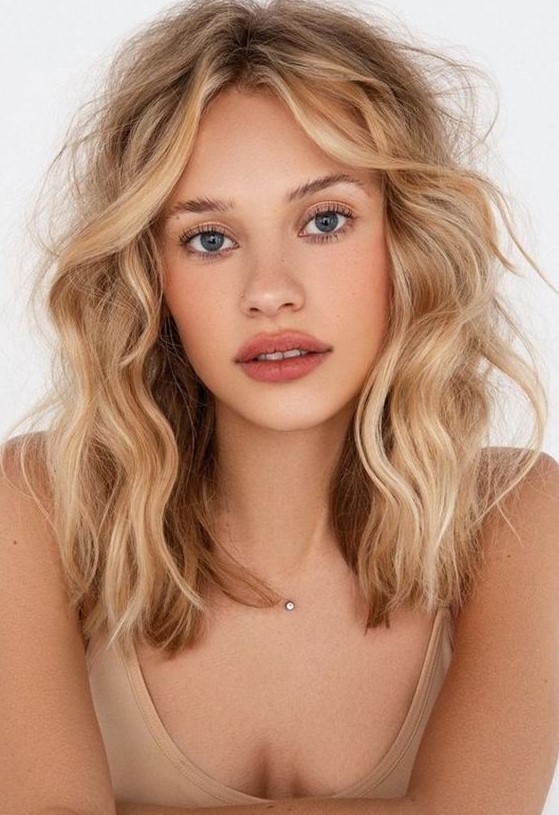 Gorgeous shoulder length blonde messy hair with darker and brighter shades, with waves and volume is amazing