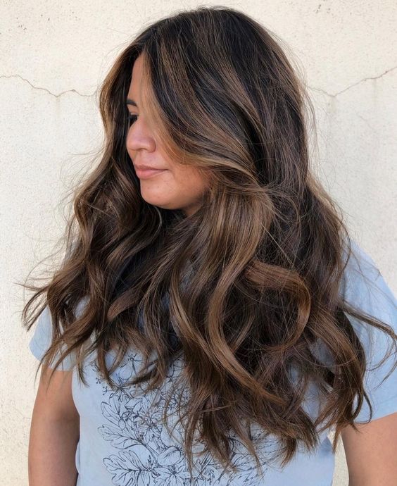 long and extra volumetric dark hair with caramel balayage with waves is a very beautiful solution that wows