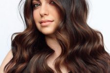 long and volumetric dark brown hair with copper balayage, with waves and volume, is a stunning solution to try