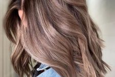long and volumetric light brown hair wiht a delicate blonde balayage and waves is a beautiful solution