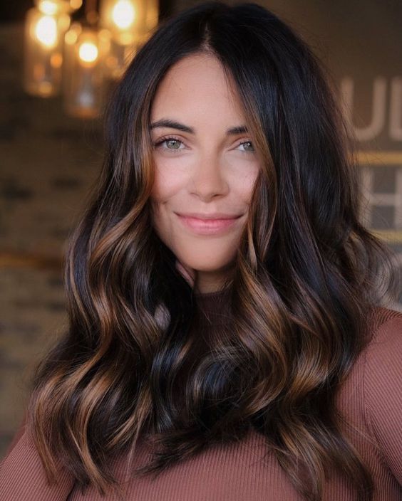 long dark brown, almost black hair with caramel balayage and waves, with volume, is a catchy and stunning idea