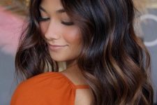 long dark brown hair with copper balayage and messy waves is a stunning solution to try