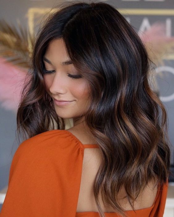 long dark brown hair with copper balayage and messy waves is a stunning solution to try