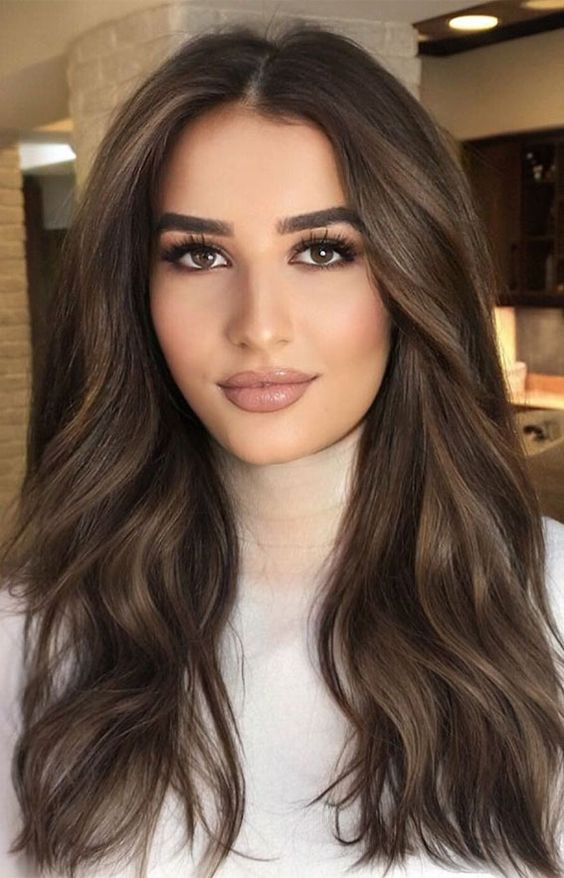 long dark brown hair with slight balayage that brigns more dimension, waves and volume, is a catchy and cool solution