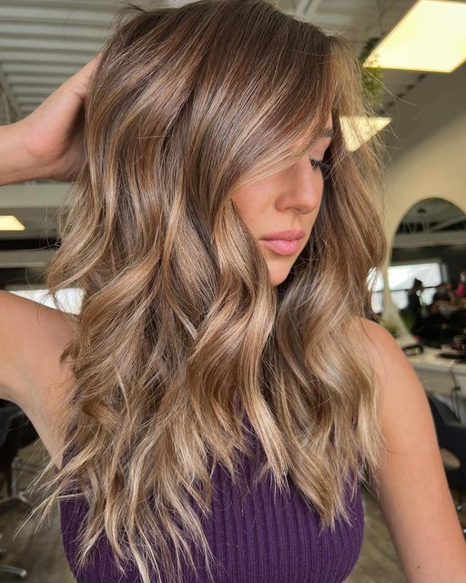 long layered light brown hair with golden blonde balayage and waves is amazing and catchy