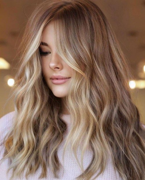 Long light brown hair accented with blonde balayage and face framing highlights and waves is amazing