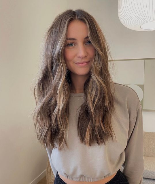 long mousy brown hair with blonde balayage, volume and waves is always a cool and chic idea to rock