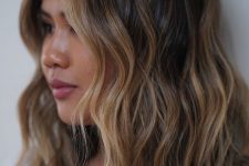 medium-length dark brunette hair with golden blonde highlights and waves is a super chic and catchy idea