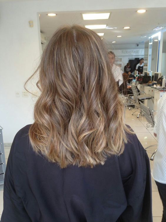 Medium length light brown hair with blonde highlights, waves and volume is a stylish and chic idea