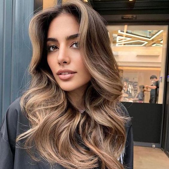 pretty long brown hair with caramel balayage, waves and volume looks spectacular