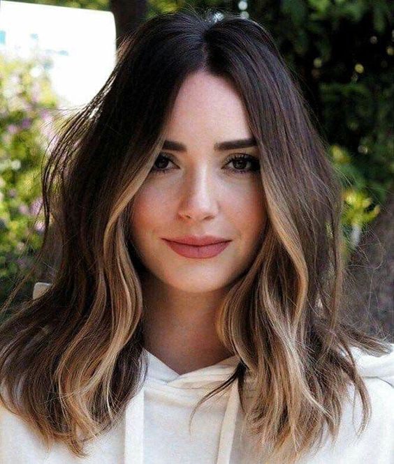 shoulder-length dark brunette hair with golden blonde highlights and some volume and waves looks wow