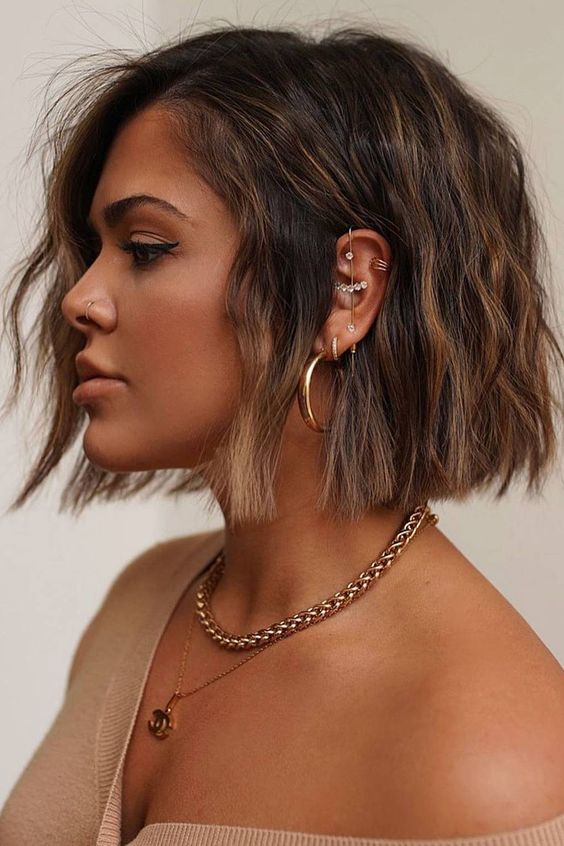 a beautiful dark blunt bob with slight caramel balayage and textural waves and a lot of volume