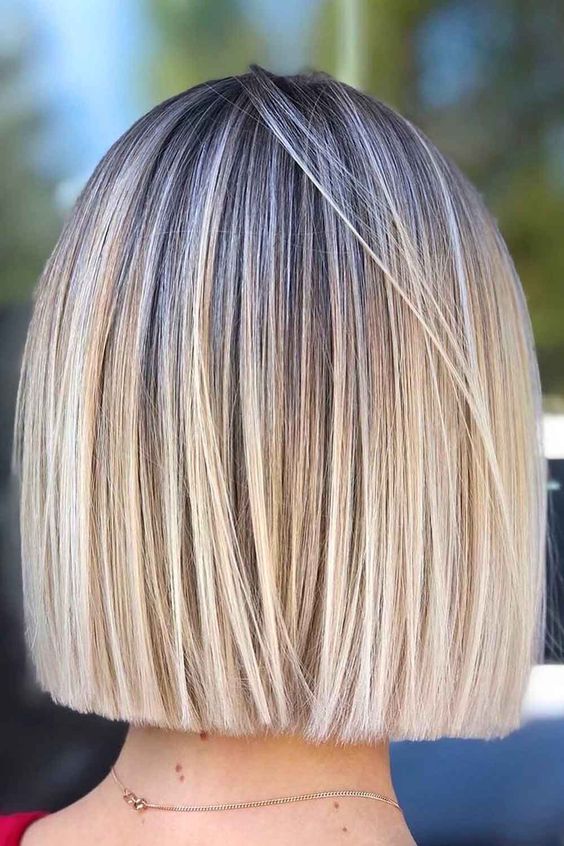 a lovely blonde blunt bob with a darker root and a lot of volume is a chic and cool hairstyle