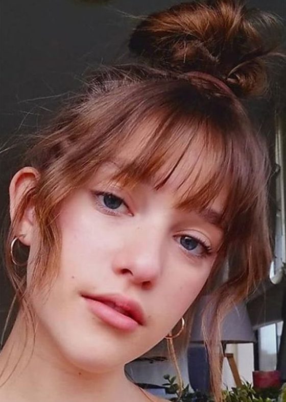 a messy top knot and Birkin bangs paired with curtain ones to frame the face as much as possible