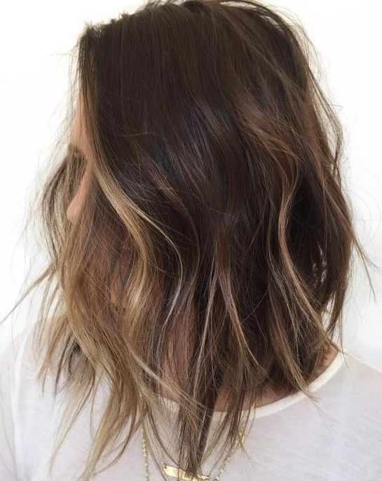 A shaggy brunette bob with face framing bronde balayage to highlight the face