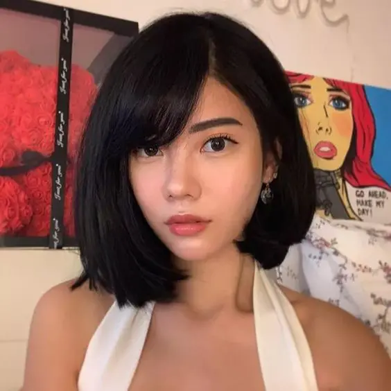 a cute black asymmetrical bob with side bangs, a lot of volume and curled ends is amazing to try