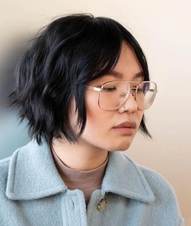 a graduated bob haircut in black, with curtain bangs is a very cool and chic idea to try right now