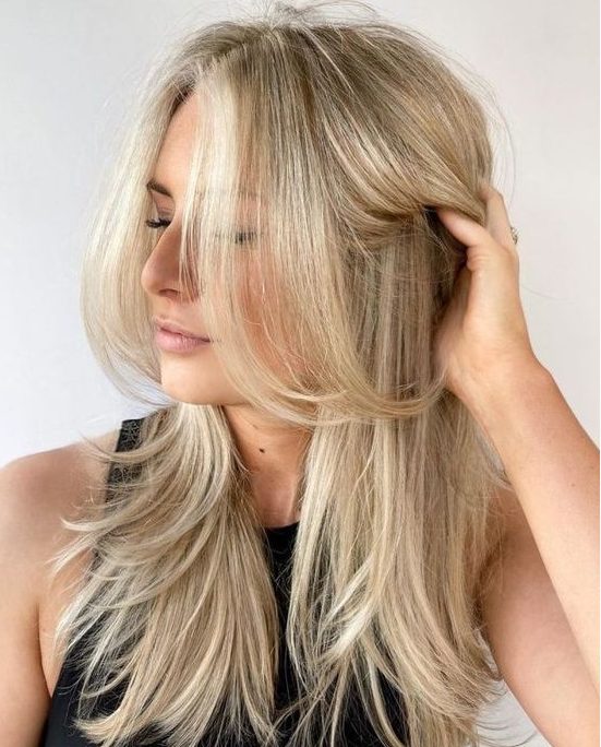 a bleached blonde butterfly haircut with curled ends and a bit of volume is a stylish idea for anyone