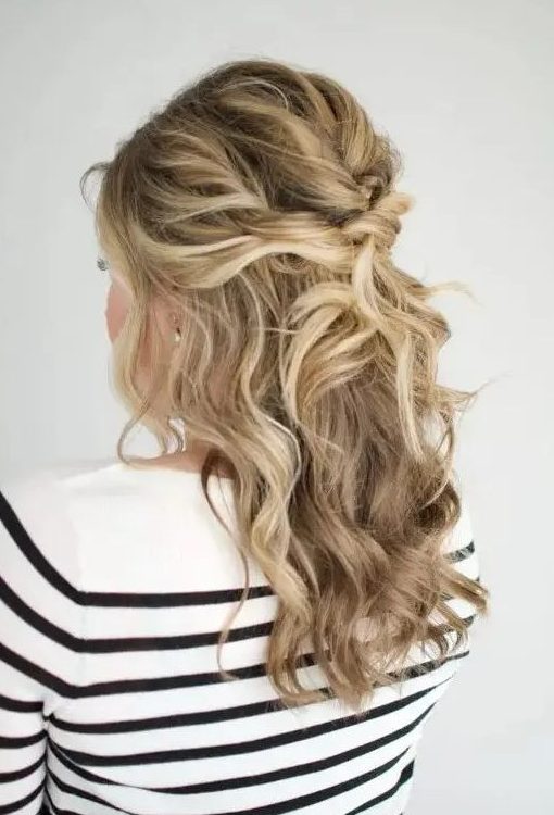 a beautiful messy twisted and wavy half updo with a bump on top and some face-framing locks is amazing for a holiday party