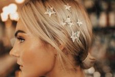 a catchy and cool low side bun with celestial bobby pins accenting one side of the head