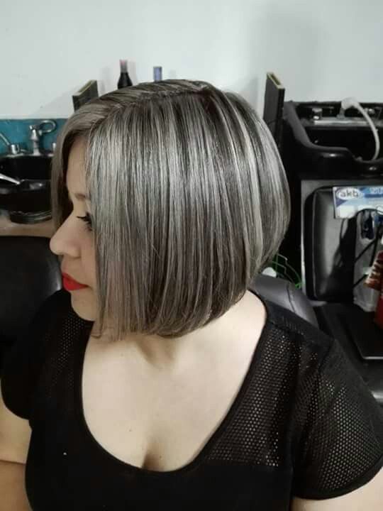a catchy black jaw-line bob with grey accents and a grey money piece, with a lot of volume and curled ends