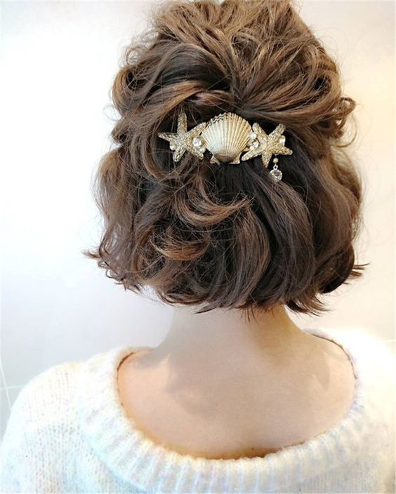 a catchy half updo with a wavy top and waves down plus a lovely coastal hair piece
