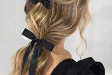 a chic and refined ponytail with waves and a bump on top plus a couple of black bows is wow