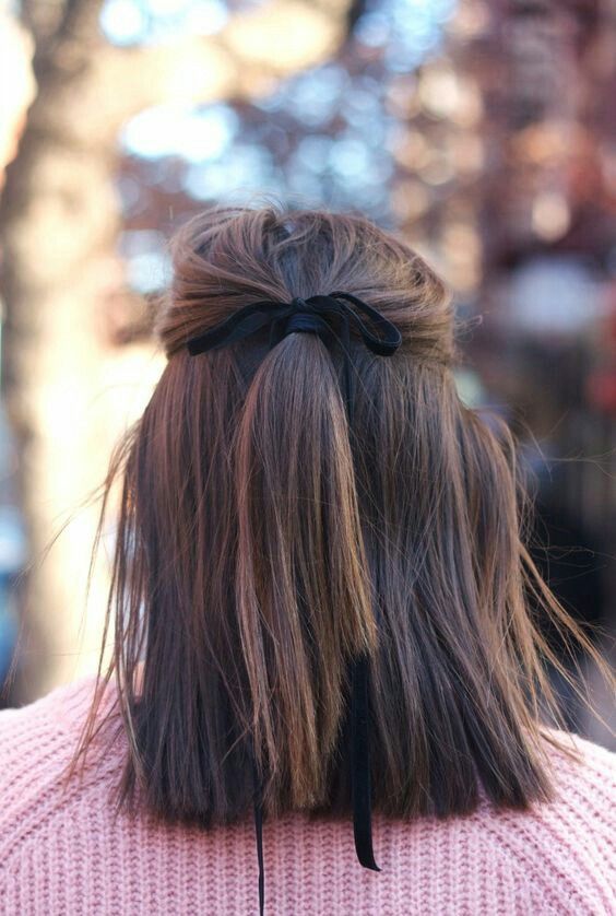 a classy half updo with a ponytail secured with a black ribbon bow and straight hair down for a cute look every day