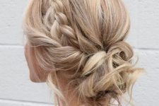 a cool messy and curly low updo with a braided halo and some locks and curls down for an effortlessly chic look