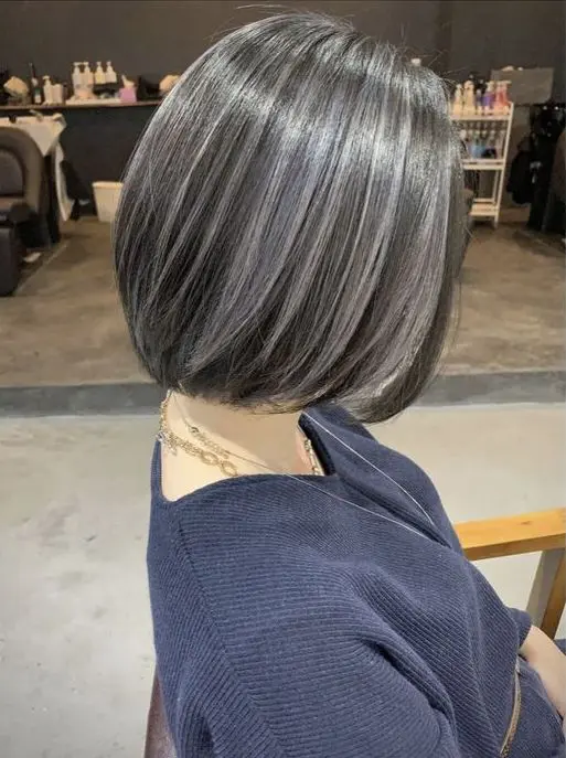 a dark, almost black midi bob with grey highlights that include naturally grey hair, too