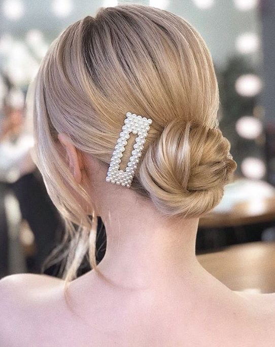 a delicate twisted low bun accented with a pearl hair clip is a lovely and chic idea for a holiday party of any kind