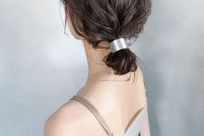 a fast and simple wavy low bun made with a metallic piece and with a messy top