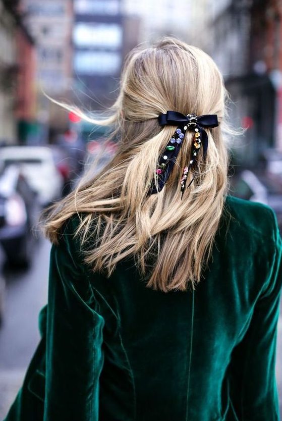 a half updo with a volume on top and a black bow accented with colorful rhinestones will be a lovely idea for the holidays