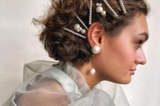 a lovely wavy half updo with multiple pearl bobby pins and statement pearl earrings is wow