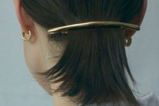 a low ponytail secured with a minimalist hair barrette is a cool modern hairstyle