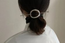a low poytail with a sleek top and a catchy silver hair piece with a hair pin is a lovely idea