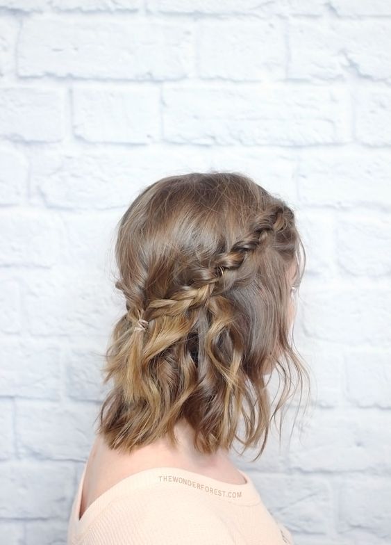 a messy braided crown haif updo with waves down is a cool hairstyle for medium length hair