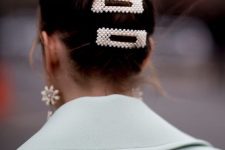 a messy bun accented with pearl hair clips and statement pearl earrings for an ultimate look