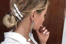 a messy low bun with a messy bump on top and beautiful pearl hair barrettes for a party look