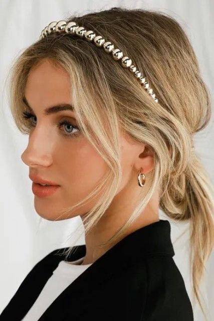 a messy low bun with some face-framing hair accented with a shiny metallic bead headband for an instant holiday feel