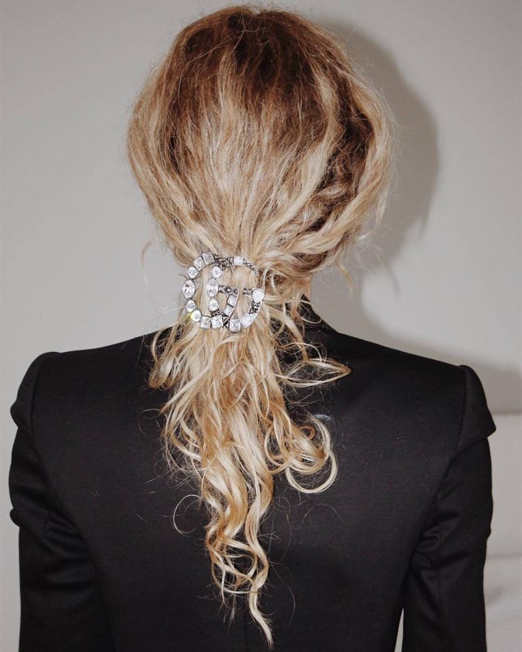 a messy wavy low ponytail accented with a shine metallic barette that instantly elevates the look