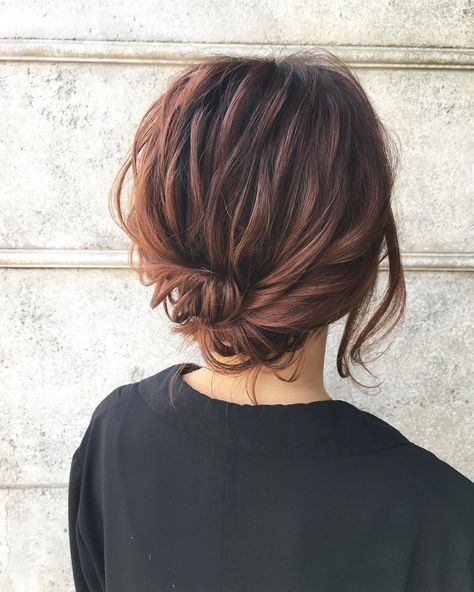 A messy wrapped low updo with wavy hair on top and face framing hair is a cool and catchy idea to try