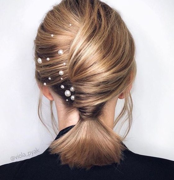 a pretty low ponytail with a twisted chignon and pearl hair pins is a cool and unusual solution for medium length hair