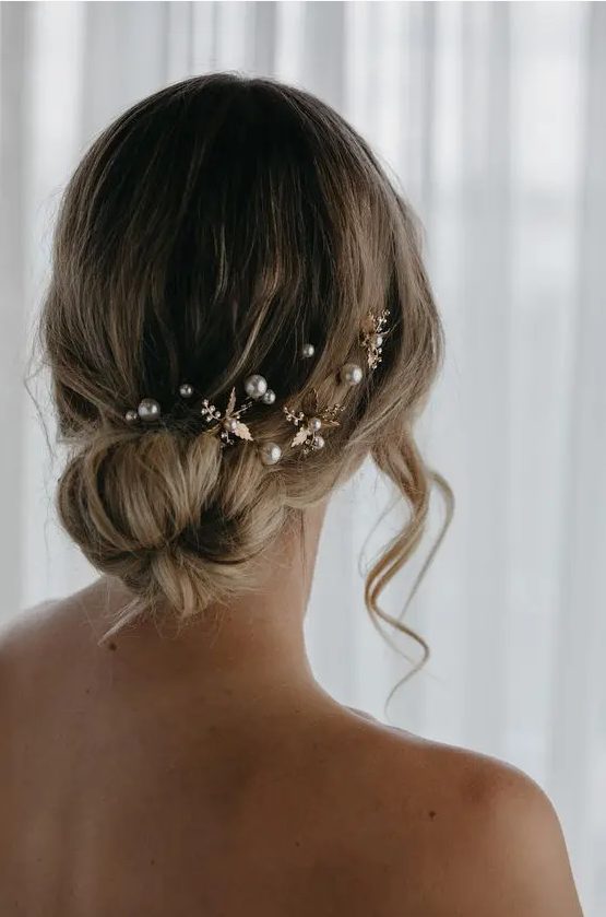 a romantic loose low ballerina bun with some pearl hair pins and flowers is a cool idea, whatever the season is