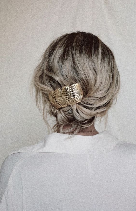 a simple and quick low updo with waves and a beautiful seashell barrette is a cool and quick to make hairstyle