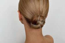 a sleek low bun wrapped with rhinestones and with a sleek top is a very eye-catchy hairstyle for the holidays