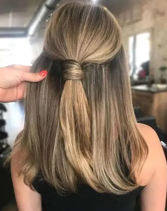 a stylish and cool half updo with a wrapped ponytail on top and straight hair down is a non-typical and very modern solution