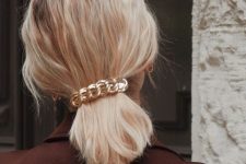 a super simple and quick Christmas hairstyle, a wavy low ponytail accented with a chain barette