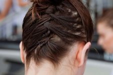 a top knot with hair secured up with bobby pins is a cool way to rock this haristyle with short hair
